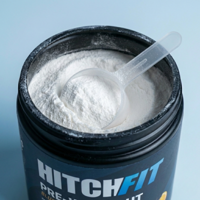 Pre workout supplement powder with scoop in an open container, muscle pump and energy boost dietary supplement